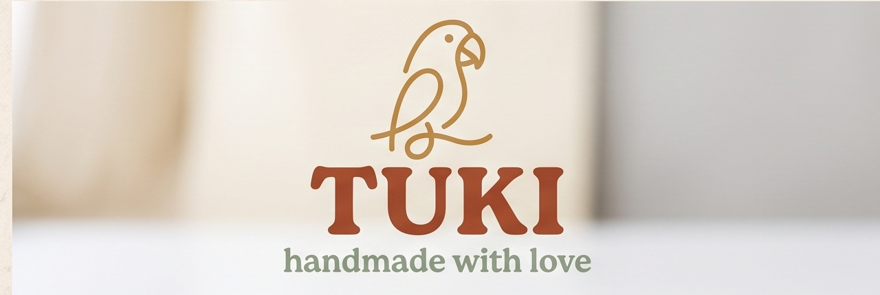 The TUKI parrot logo over a soft studio backdrop